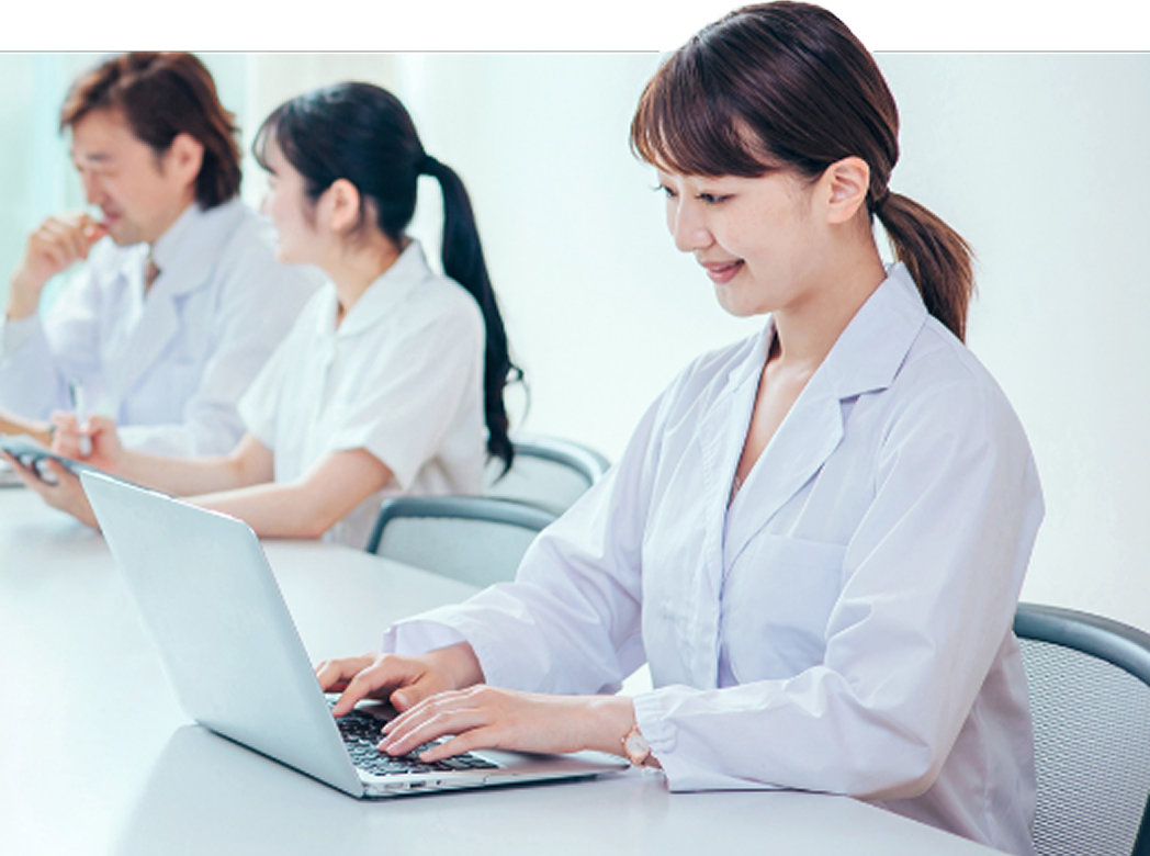 メディカルクラークが中央に位置し、医師・看護師が各々仕事をしている様子の画像